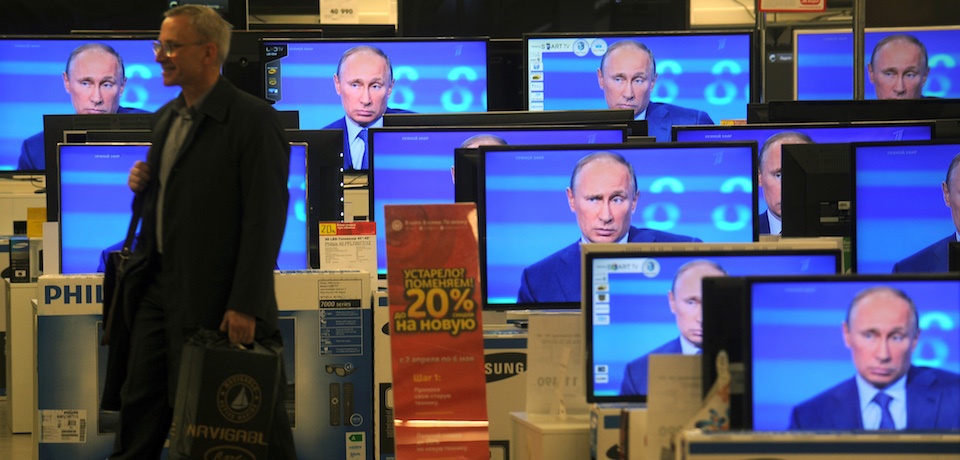 A customer walks past the TV screens in a shop in Moscow, on April 25, 2013, during the broadcast of President Vladimir Putin's televised question and answer session with the nation. AFP PHOTO / ANDREY SMIRNOV (Photo credit should read ANDREY SMIRNOV/AFP/Getty Images)